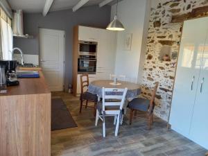 a kitchen and dining room with a table and chairs at Lac Grand Lieu : maisonnette au calme avec jardin in Saint-Lumine-de-Coutais