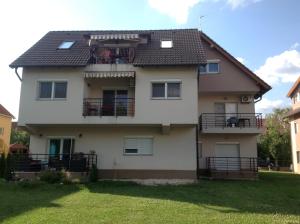 a house with a balcony on the side of it at Bella Apartman in Balatonfüred