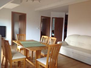 a dining room with a table and chairs and a couch at Bella Apartman in Balatonfüred