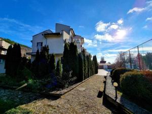 une maison avec une rangée d'arbres dans une cour dans l'établissement Студия Лазарови, à Balchik