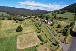 LilydaleCherry Top Farmstay - Boutique Eco Village的享有农场的空中景色,有房子和道路