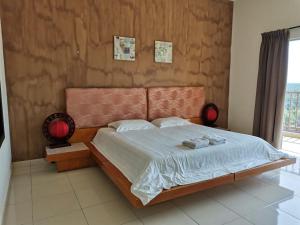 a bedroom with a bed with two towels on it at Gold Coast Morib Resort in Banting