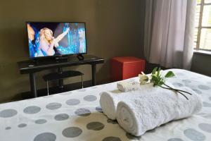 a hotel room with a bed with a towel on it at Cozy Hatfield Condo in Pretoria