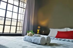 a bedroom with a bed with a stuffed animal on it at Cozy Hatfield Condo in Pretoria +9 photos
