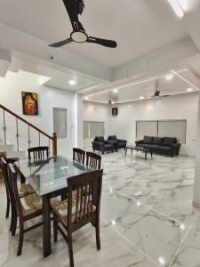 a room with a table and chairs and a couch at Vedganga Villa - Homestay in Kolhapur