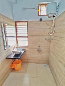 a bathroom with a sink and a shower at Vedganga Villa - Homestay in Kolhapur
