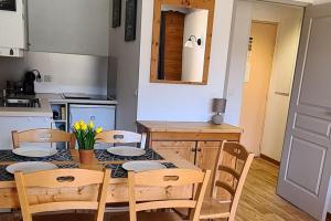 une cuisine avec une table en bois et des chaises ainsi qu'une salle à manger dans l'établissement T2 Cosy à 50m des pistes, 6 pers Puystvincent 1800, à Puy-Saint-Vincent