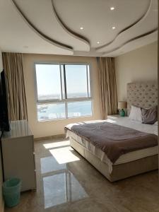 sypialnia z dużym łóżkiem i dużym oknem w obiekcie Amwaj hotel Salalah Mirbat w mieście Salala