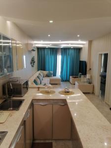 a kitchen with two sinks and a living room at Amwaj hotel Salalah Mirbat in Salalah