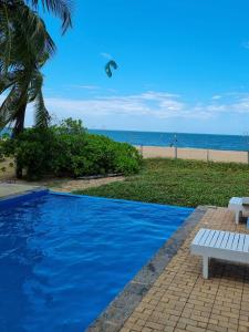 a swimming pool next to a beach with a kite in the sky at Wellé Wadiya Beach Villa in Kalpitiya