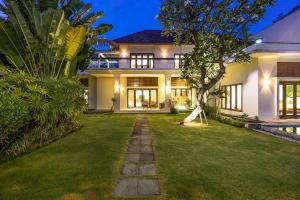 a house with a lawn in front of it at Bali Villa Lotus in Seminyak