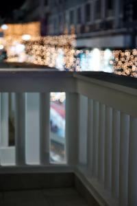 - une vue sur une balustrade blanche sur un balcon la nuit dans l'établissement ODI ARTSPITALITY, à Vólos