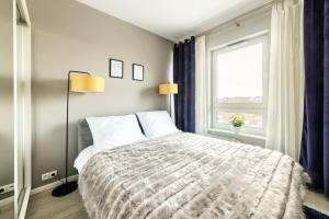 Un dormitorio con una cama grande y una ventana en Tarasowy Apartamenty Luksusowe en Olsztyn
