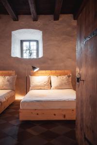 sypialnia z drewnianym łóżkiem i oknem w obiekcie Castel Maurn w mieście San Lorenzo di Sebato