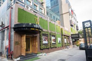 a building with a green wall on a city street at Golden Parkk Hotel in Kolkata