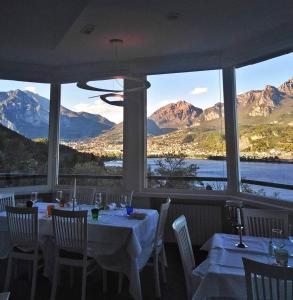 PescateにあるHotel Ristorante Parco Belvedereの山の景色を望むレストラン(テーブル、椅子付)