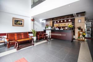 a lobby with wooden benches and a bar at Nam A Hotel - Central City in Da Nang