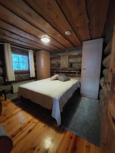 a bedroom with a large bed in a cabin at Isokelo Log Apartments in Salla