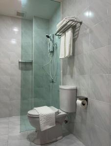 a bathroom with a toilet and a glass shower at TJ Boutique Hotel in Uthai Thani