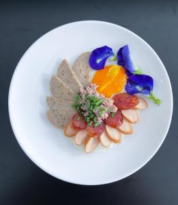 a white plate with cookies and flowers on it at TJ Boutique Hotel in Uthai Thani
