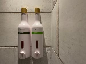 two white bottles are hanging on a wall at We Come Hostel in Taipei