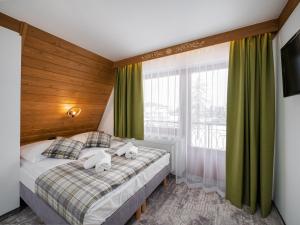 a bedroom with a bed with two towels at Leśne Apartamenty in Białka Tatrzanska