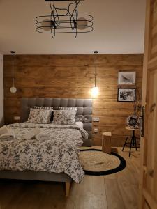 um quarto com uma cama e uma parede de madeira em Apartament Gorsky em Poronin