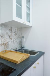 - une cuisine avec un évier et une planche de coupe en bois dans l'établissement Suite Romantique, à Hésingue