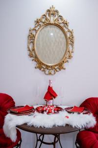 a table with red chairs and a mirror on a wall at Suite Romantique in Hésingue