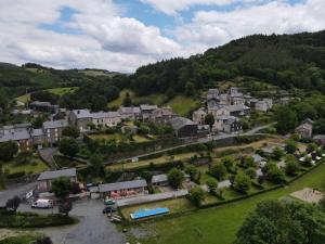 an aerial view of a small village in the hills at Camping Le Jardin 3 étoiles - chalets, bungalows et emplacements nus pour des vacances nature le long de la rivière le Gijou in Lacaze