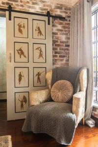 a living room with a chair and a wall with pictures at La Casa Nostra Villa Rose Garden Bella in Hillcrest