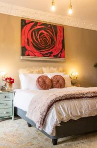 1 dormitorio con 1 cama con una pintura en la pared en La Casa Nostra Villa Rose Garden Bella, en Hillcrest