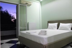 een slaapkamer met een bed met handdoeken erop bij Minas new apartment 2mins walking from Stoupa beach in Stoupa