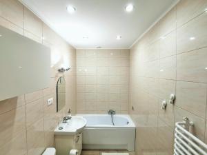 a bathroom with a bath tub and a sink at Apartament Seven in Legnica