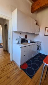 a kitchen with white cabinets and a microwave at Appartamento il Palazzone in Capraia