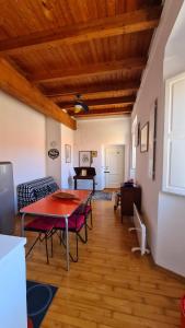- un salon avec une table, des chaises et un piano dans l'établissement Appartamento il Palazzone, à Île de Capraia