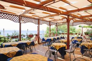a restaurant with tables and chairs with the ocean in the background at PARADISO Hotel Ristorante in Reggio di Calabria