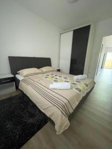 een groot bed in een witte kamer met een groot raam bij Apartman Dorotea in Zaton