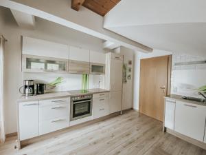 una cucina con armadietti bianchi e pavimenti in legno di Ferienhaus Lentsch a Jerzens