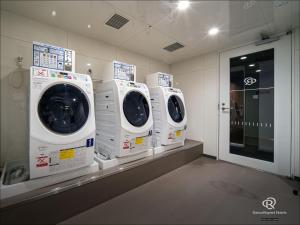 three washing machines are lined up in a room at Daiwa Roynet Hotel Kanazawa Eki Nishiguchi in Kanazawa