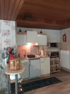 a kitchen with white appliances and a table in a room at Ferienwohnung Atlantis in Hemfurth-Edersee