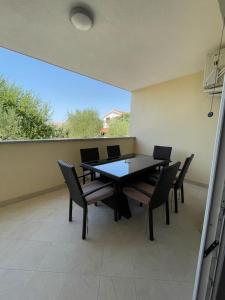 a dining room with a table and chairs on a patio at Apartman Dorotea in Zaton