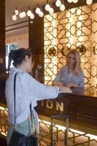 a woman standing in front of a piano at Bilgehan Hotel in Antalya