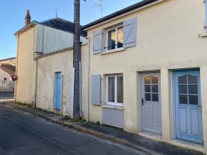 a building with blue doors on the side of a street at Maisonnette design Le Cosy - Marché à 3mn à pied - Parking gratuit à 50m - Amazon Prime - in Surgères