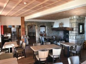 a restaurant with tables and chairs and a stone fireplace at La Bastide de Sanilhac in Sanilhac