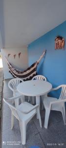 una mesa y sillas blancas y una pared azul en Linda casa de condomínio com piscina, na Praça 21, en Porto de Galinhas