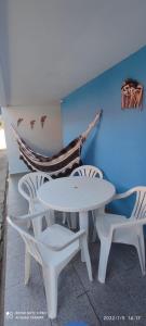 a white table and chairs and a blue wall at Casa de condomínio para 6 pessoas, tudo a pé, perto do centro e piscinas naturais in Porto De Galinhas