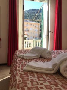 een bed in een kamer met een raam bij Hotel B&B Giardino delle Rose Bike&Breakfast in Finale Ligure
