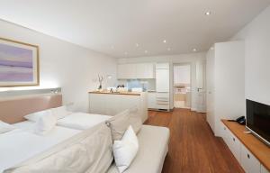 a white living room with a couch and a kitchen at 35qm Deluxe Apartment Suites im Stil Design Hotel Vosteen Nähe der Kaiserburg in Nuremberg