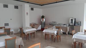 un ristorante con tavoli e sedie bianchi e una cucina di Hotel Florida a Piove di Sacco